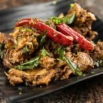 Spicy Indian chicken fry served on a dark plate